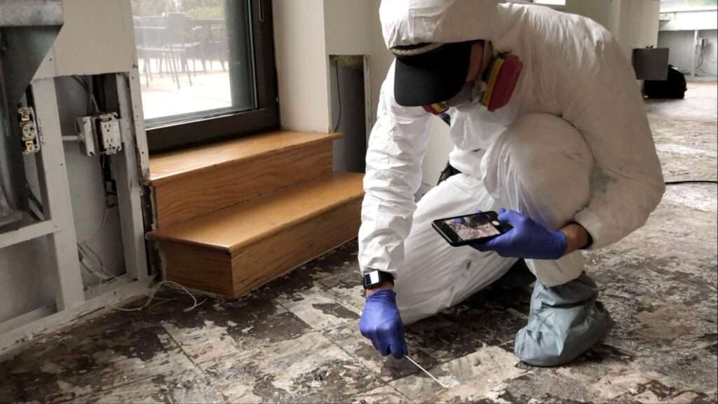 mold inspector sitting on floor testing mold.