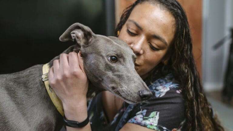 A woman showing affection for her dog