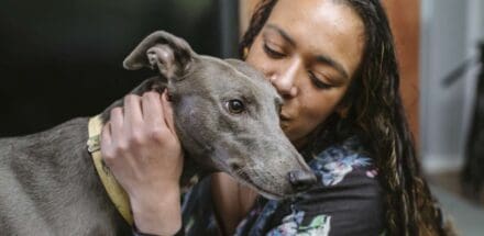 A woman showing affection for her dog